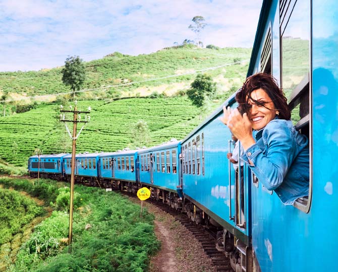 Female adventure traveller experiencing the amazing surroundings on view from the train journey, Kandy to Ella 0ne of the most memorable journeys any adventure traveler will ever experience is the Train from Kandy to Ella