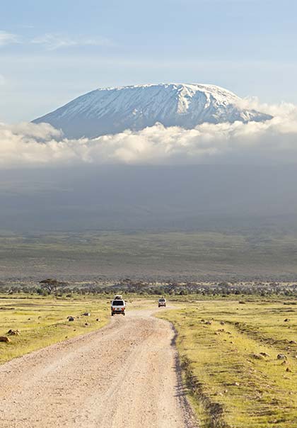 Best time to visit Tanzania, Mount Kilimanjaro jeeps driving along the road towards mount kilimanjaro tanzania africa