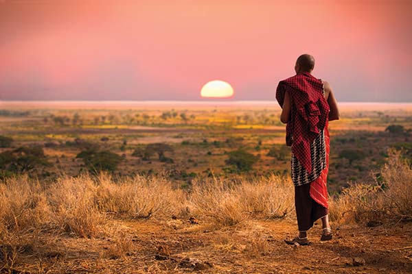 Geography and landscape of Tanzania tanzanian man looking at the sunset over african landscape in tanzania
