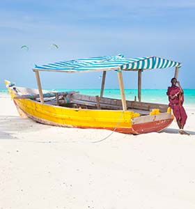 Culture, religion and etiquette in Tanzania boat on the white beach of zanzibar in tanzania