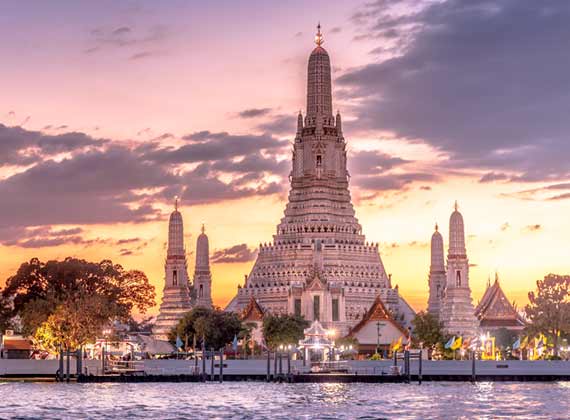 View at sunset of Wat Arun buddhist temple in bangkok along the river is a recommended visit whilst on holiday in Bangkok
