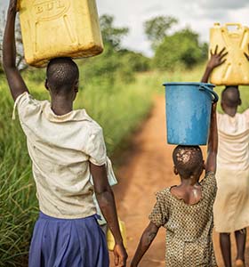 Religion, culture and etiquette in Uganda group of young people carrying water in uganda