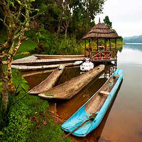 Best time to visit the River Nile in Uganda lakes and small traditional boats in Uganda next to green vegetation