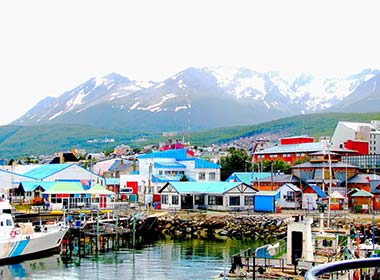 small fishing port town with colourful buildings and mountain background ushuaia best places to visit in argentina