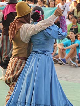 a couple dancing in traditional argentinian dress at the cosquin folk festival in argentina