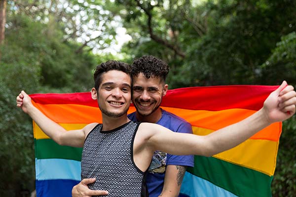 a couple holding a rainbow flag for gay pride festival