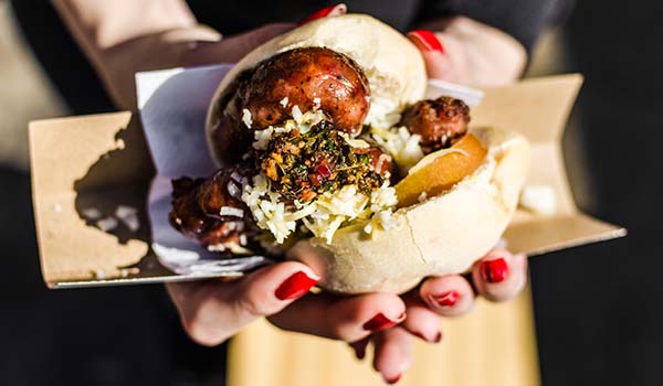 Cost of food & drink in Argentina woman holding choripans street food in argentina