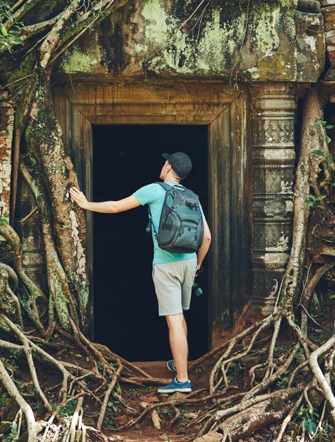 solo male traveller explores Angkor Wat Holiday adventure tourist explore the door way on ancient ruins in the amazing Angkor Wat