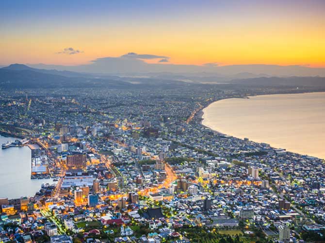 Hokkaido skyline from Mt. Hakodate adventure travellers on top of Mt. Hakodate overlook Hokkaido skyline