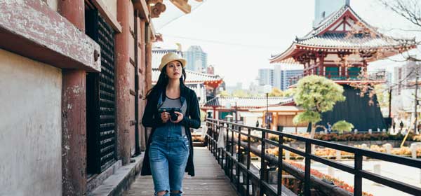Solo female traveller exploring historic Osaka young female solo traveller visits osaka, japan whlst on a holiday trip
