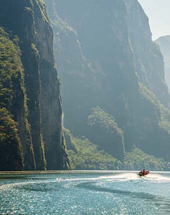 Mexico Travel Advice riding a jet ski on paradise beach in Mexico with cliffs and jungles along the shore