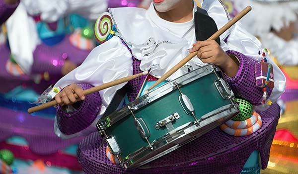 Cape Town Minstrel Festival, South Africa person dressed up as a minstrel playing a drum in purple clothing for the cape town minstrel festival in south africa