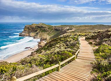 wooden boardwalk leading to the tip of cape peninsula south africa blue sea