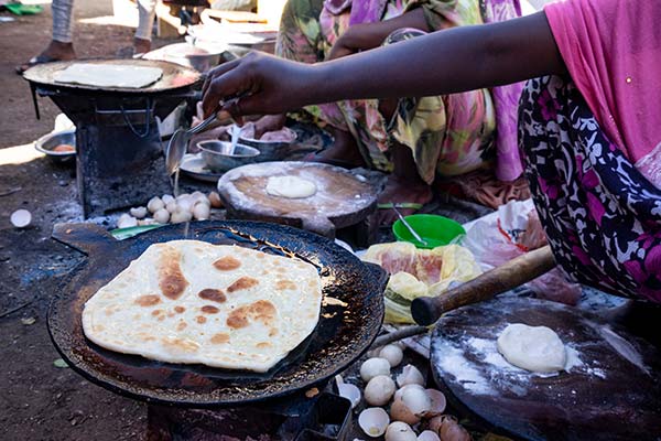 women in zimbabwe cooking traditional food at a food market festival