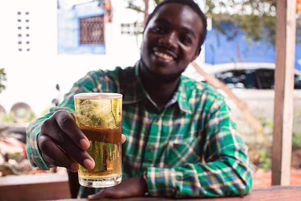 Lion Larger Summer Beer Festival man in zimbabwe holding up a glass of lion larger beer at a beer festival