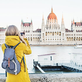 solo female traveller looking at the parliament buildings in budapest hungary best time to visit eastern europe