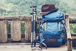 What to pack for a holiday to Western Europe. Blue backpack with a camera tripod