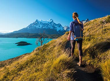 Woman hiker walks on the trail in the Torres del Paine National Park, Chile