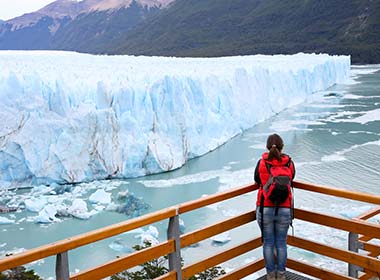 Tourist gazing in front of Perito Moreno Glacier on footbridge