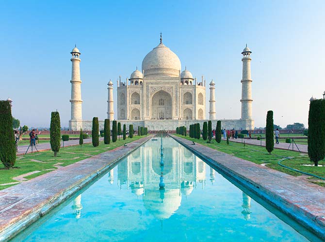 A blue sky with the gardens and pool outside the Taj Mahal in Agra India Asia