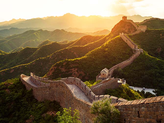 Sunset over the rolling green hills at the great wall of China one of the 7 new wonders of the world