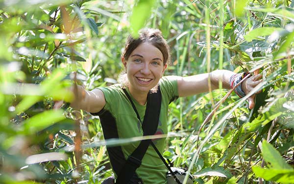 Female solo traveler in the amazon jungle explores the vegetation surrounding her