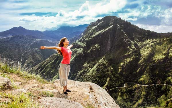 female solo adventure traveller hiking up little adams peak looking over the incredible scenic landscape