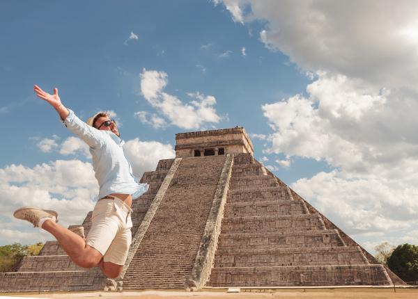 Male single tourist traveller with Tucan Travel on his solo tour infront of ancient Chichen Itza, Mexico single traveler in awe of his surroundings infront of Chichen Itza, Mexico