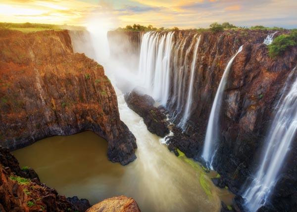 Great solo traveller photo of Victoria Falls, Zambia and Zimbabwe with Tucan Travel when touring Africa single traveler in awe of her surroundings with the view over Victoria falls in Zambia and Zimbabwe