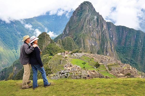 Couple travelling in a group admiring Machu Picchu, Peru a couple at machu picchu, group travel to peru, tours to peru, machu picchu tours, hiking the inca trail, inca trail tours