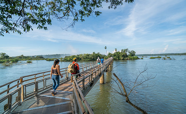 Travellers walking along the entrance to Iguazu Falls value for money, money saving trips, tour discounts, money off travel