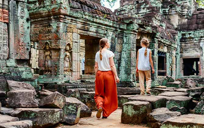 Mother and daughter exploring the temple complex of Angkor Wat on family holiday