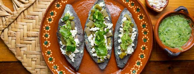 tlacoyos are a doughy snack with a variety of savoury fillings and a cooked on a griddle