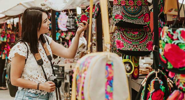 Single traveller wanders the markets when you get free time on your group holiday tour wander around the local markets and see what bargains and authentic street dishes you might find as they are full of culture