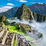 South America travel region represented by the historic ancient Peruvian ruins of Machu Picchu which is situated on the Andes mountains amongst the clouds, Peru.