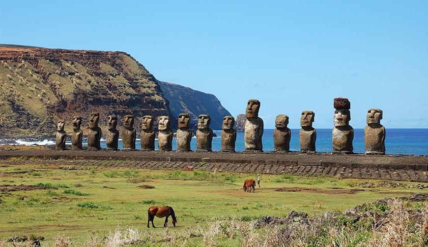 Horses grazing in front of the Moais at Ahu Tongariki on Easter Island, Chile