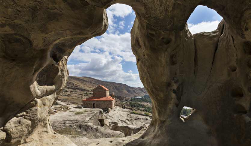 Cave city of Uplistsikhe with the basilica church in the background, in Georgia Cave city of Uplistsikhe with the basilica church in the background, in Georgia