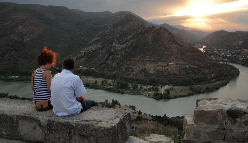 A couple admires the merging of the Aragvi and Kura rivers from the viewing point of the Jvari Monastery near the town of Mtskheta in Georgia