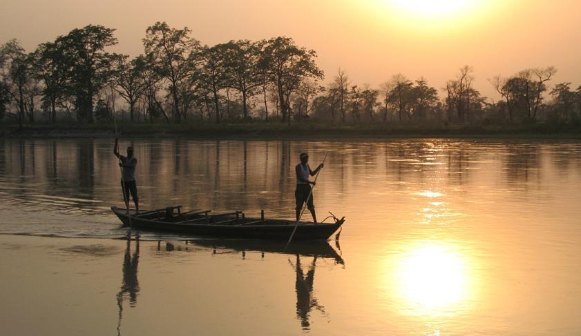 Locals punting along the river in Chitwan National Park, Nepal Locals punting along the river in Chitwan National Park, Nepal